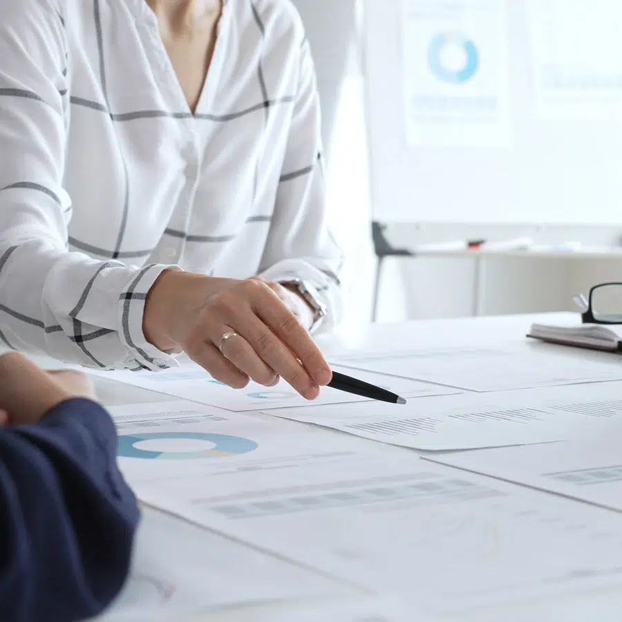 Personne pointant des documents lors d'une réunion